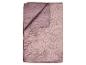 Une couverture matelassée mauve pliée avec un motif floral.