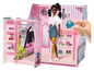 Une Barbie Boutique rose avec une poupée, des vêtements et des accessoires.