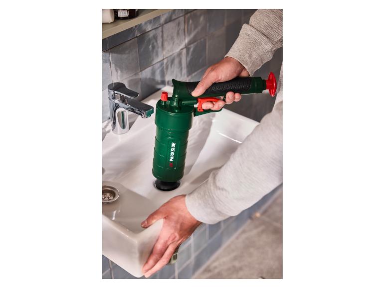Un homme utilise un déboucheur d'évier Parkside pour nettoyer un lavabo de salle de bain.