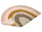 Un tapis en laine rose, beige et jaune en forme d'arc-en-ciel.
