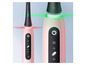 Deux brosses à dents électriques Oral-B roses avec différents modes.