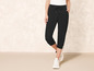 Pantalon de jogging noir cropped avec des baskets blanches.