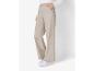 Pantalon beige à jambes larges et baskets blanches.