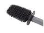 Brosse en silicone noire avec un manche gris, présentant diverses picots texturés