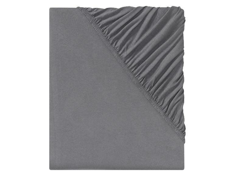 Un drap-housse gris avec élastique.