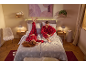 Un couple en pyjamas à carreaux rouges assortis se détend sur un lit douillet avec du linge de lit d'hiver.