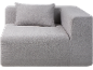 Canapé d'angle modulaire gris avec coussin, revêtu d'un tissu à texture fine.
