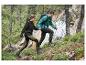 Un couple se promène dans la forêt avec des vestes imperméables et des chaussures de randonnée.
