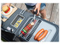 Un enfant joue avec un barbecue en jouet avec des saucisses, un hamburger et une brochette.