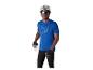 Homme en maillot de cyclisme bleu, short noir, casque et lunettes de soleil, tenant une gourde.