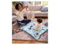 Une mère photographie son bébé qui joue sur un tapis de jeu avec des jouets.