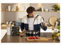 Un homme dans la cuisine avec une casserole, un porte-épices et une planche à découper.