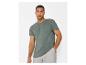 Homme en t-shirt vert à manches courtes avec poche et short gris.