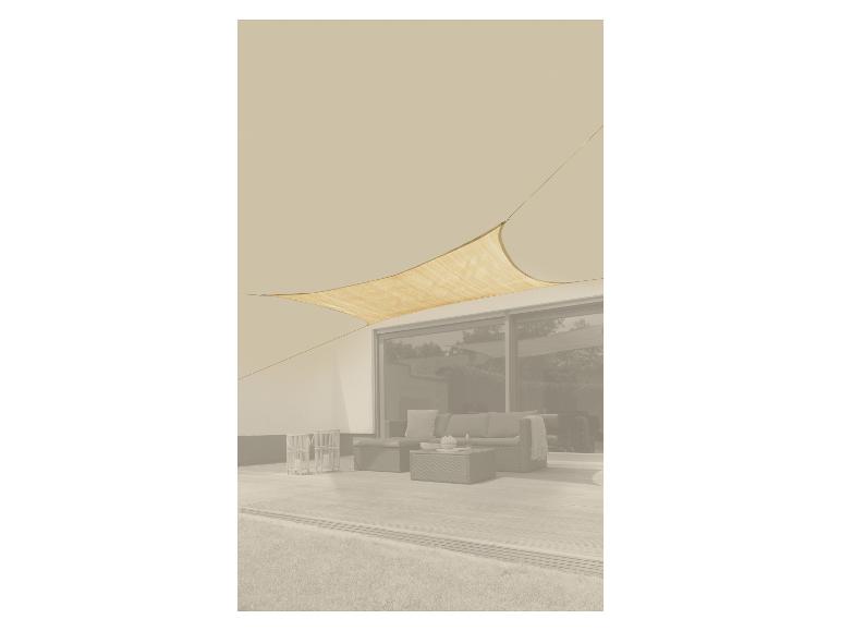 Voile d'ombrage beige au-dessus d'une terrasse avec mobilier de jardin.