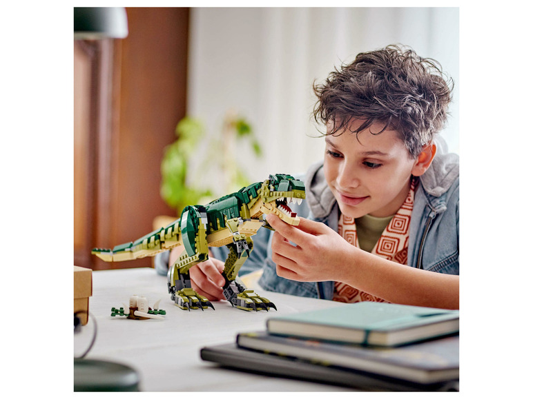 Un enfant joue avec un dinosaure LEGO T-Rex.