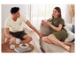 Un homme et une femme en tenue décontractée, avec une tasse de café sur le canapé.