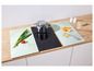 Une plaque de cuisson avec une casserole, des planches à découper et des légumes.