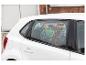 Une voiture blanche avec un pare-soleil Marvel Avengers à la fenêtre.