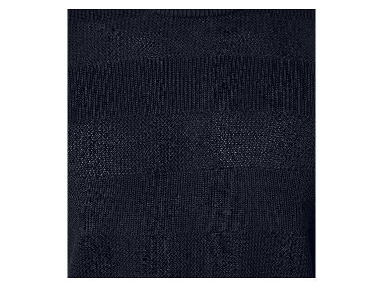 Gros plan sur un pull en maille bleu marine à motif ajouré.