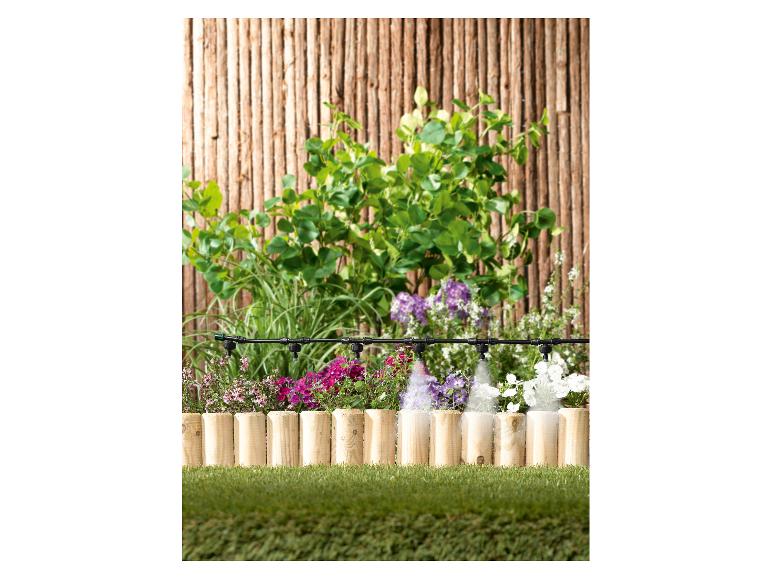 Système d'irrigation de jardin avec arroseurs arrosant des fleurs et des plantes colorées.