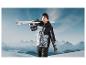 Homme en veste et pantalon de ski portant des skis en montagne.