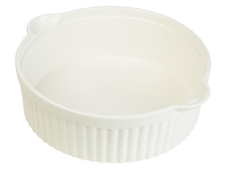 Un plat à gratin blanc avec des bords cannelés.