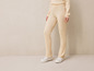 Pantalon beige en tricot avec des baskets blanches.