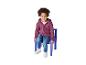 Enfant assis sur une chaise bleue, portant un sweat à capuche violet et un jean.