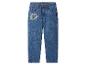 Jean en denim bleu pour enfants avec un patch coloré de chien de dessin animé sur la jambe gauche.