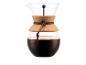 Cafetière en verre avec poignée en liège et cordon en cuir, remplie de café.