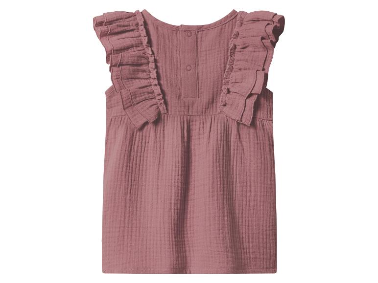 Blouse rose sans manches pour enfant avec volants et boutons au dos.
