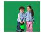 Deux enfants joyeux en gilets polaires bleus et pantalons de pluie, se tenant la main et un seau vert.