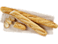 Baguettes fraîchement cuites, une tranchée, sur un linge clair.