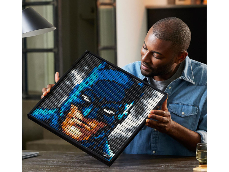 Un homme tient un portrait de Batman LEGO® Art.
