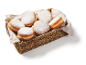 Beignets au sucre glace dans un panier en osier avec un tissu.