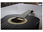 Une guitare acoustique noire avec un trou de son orné.