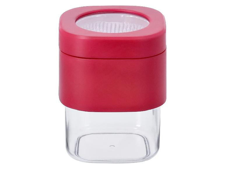 Un récipient à épices rouge avec un couvercle transparent.