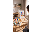 Une personne peignant sur une toile avec des tubes de peinture acrylique sur une table en bois.