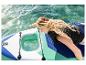 Femme sur un paddleboard avec fenêtre transparente, main touchant l'eau.