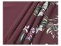 Tissu bordeaux à motif floral, plié en plis.