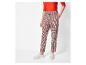 Femme en pull rouge et pantalon à carreaux avec des baskets blanches.