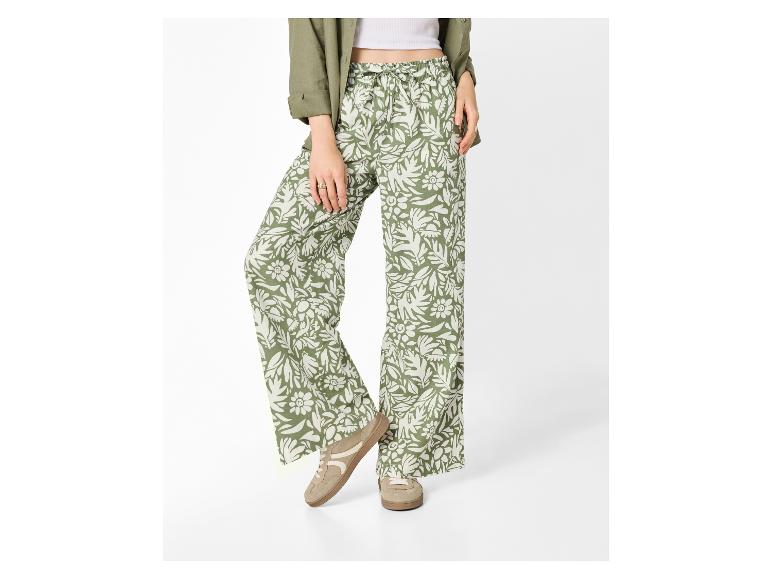 Pantalon femme à imprimé floral, chemise verte et baskets blanches.