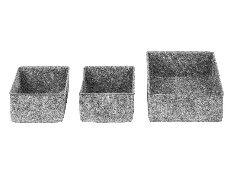 Trois boîtes de rangement en feutre gris de tailles variées, avec des façades inclinées.