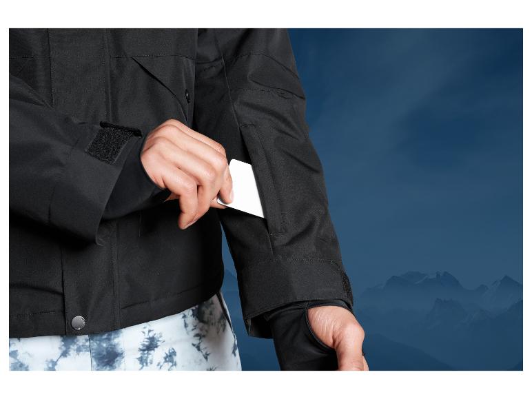 Veste noire avec des poches et une fermeture à boutons devant des montagnes.