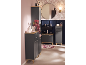 Salle de bain avec meubles gris foncé et accents bois, mur rose et papier peint floral.