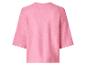 Pull en maille rose avec manches raglan et col rond.