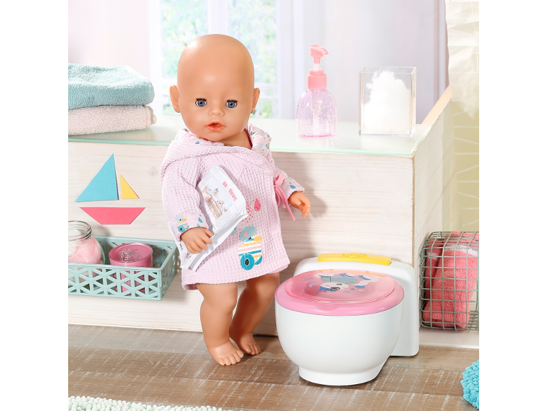 Poupée en peignoir avec un pot, des serviettes et des accessoires de salle de bain.