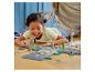 Une enfant joue avec des LEGO® City : routes, feux et végétation.