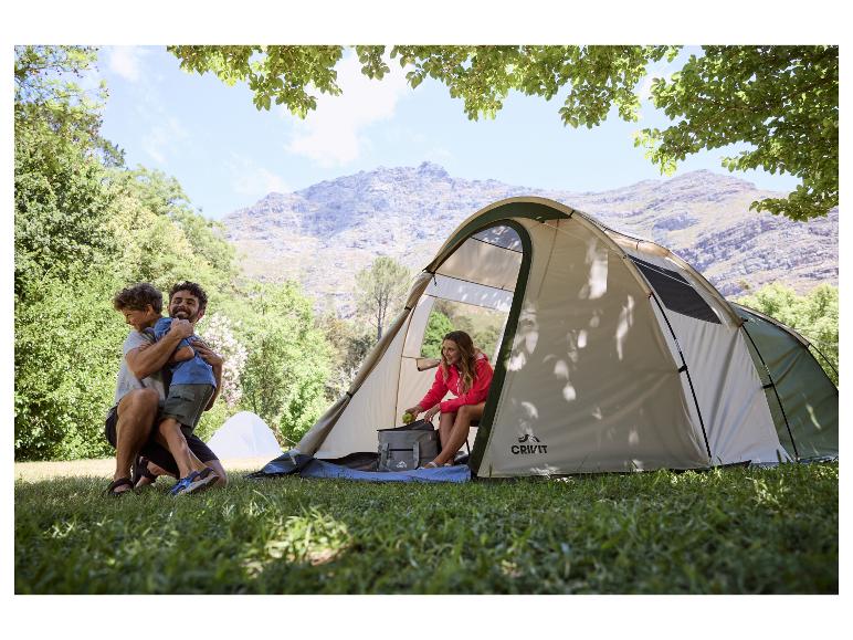 Famille en camping avec sac à dos et tente dans les montagnes.
