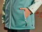 Gros plan sur une veste softshell vert clair avec une poche.